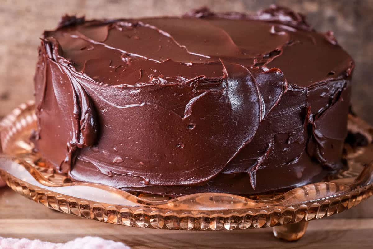 Finished Chocolate Fudge Cake showing glossy rich chocolate ganache completely covering cake.