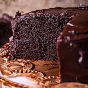 Chocolate fudge cake cut into showing soft moist sponge and richly intense creamy ganache.