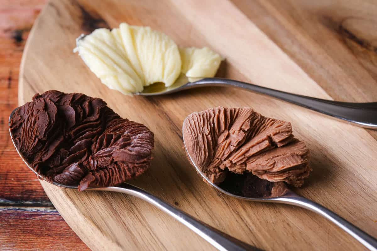Milk chocolate, dark chocolate and white chocolate ganache cooled and scraped up with teaspoons so the ganache looks beautifully set and rippled showing the right consistency for chocolate truffles.