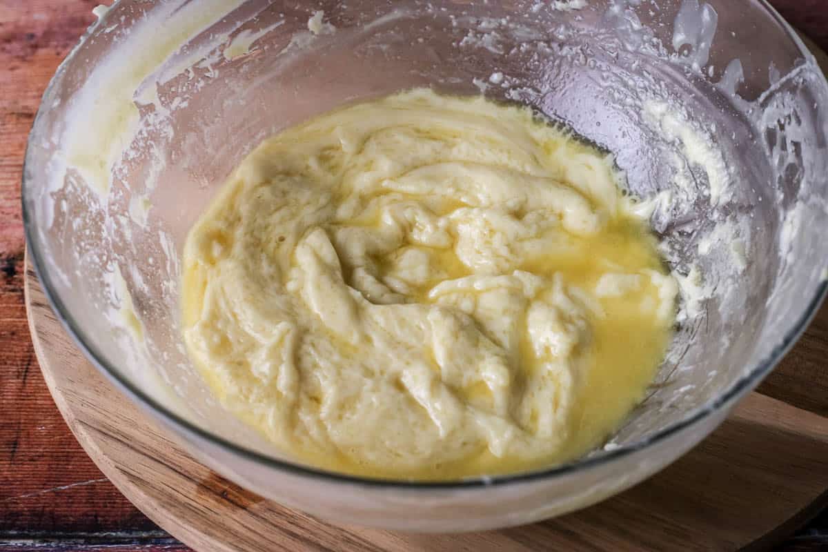 A bowl of split white chocolate ganache showing an oily top where the fat has separated and risen to the top of the ganache.