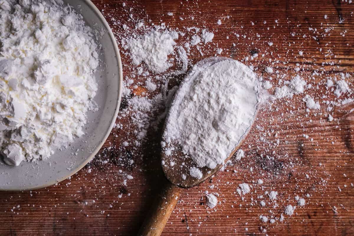 A spoon of cornflour showing it's white and powdery.