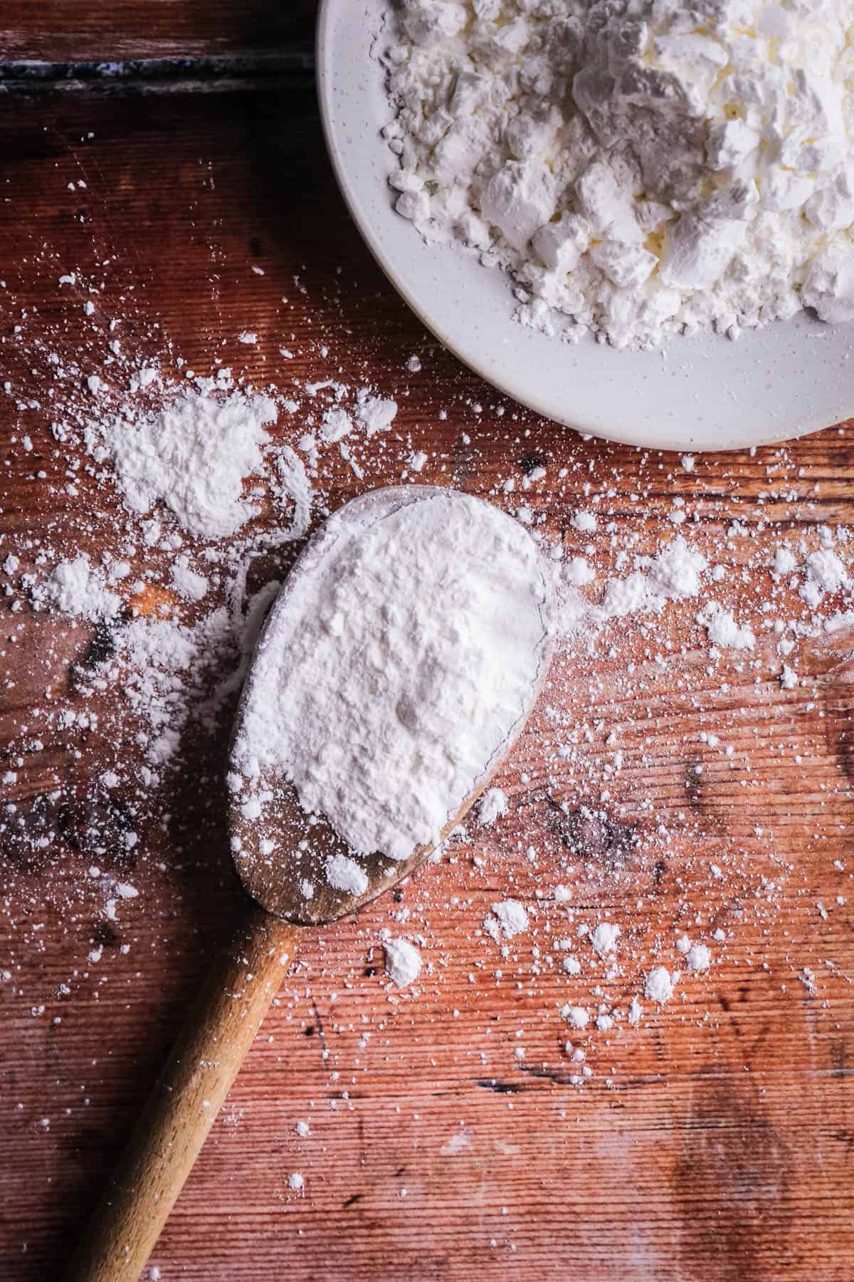 A spoon of cornflour showing it's white and powdery.