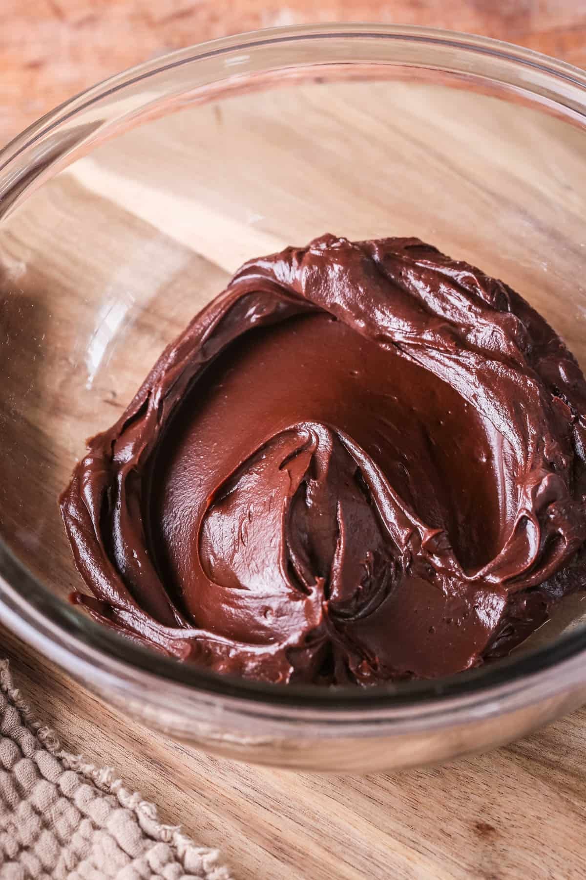 Thick, smooth and glossy Dark Chocolate Ganache set to a fudgy consistency in a bowl.