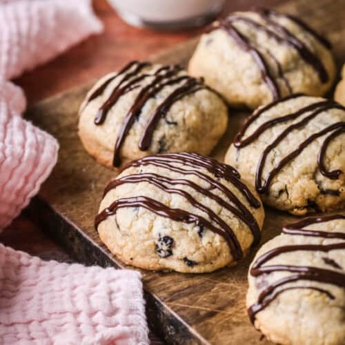 Easter Cookies packed with marzipan, currants, spice and chocolate resting on a wooden board.