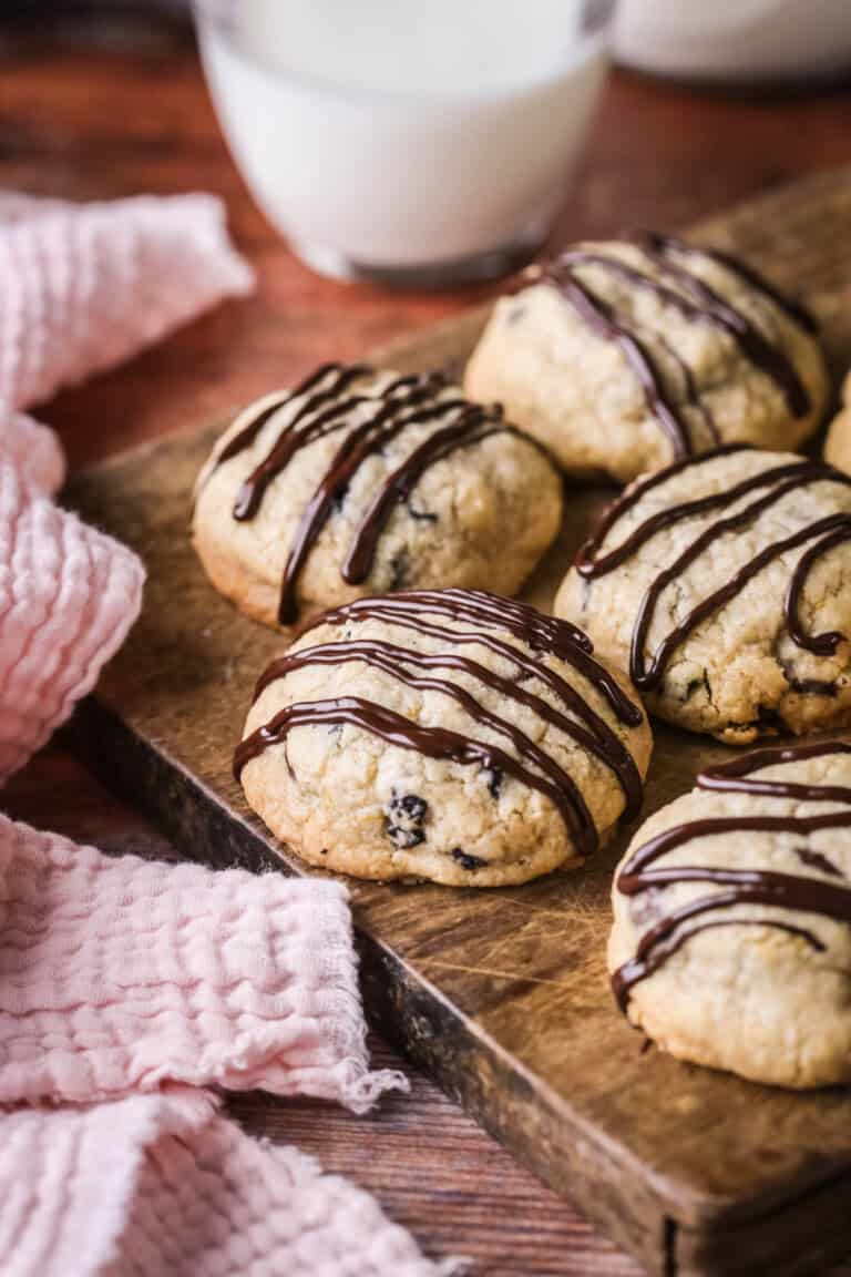 Easter Cookies packed with marzipan, currants, spice and chocolate resting on a wooden board.