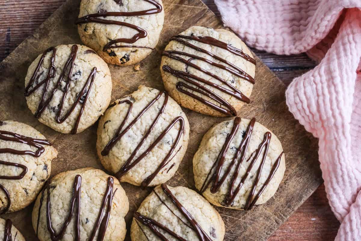 Easter Cookies packed with marzipan, currants, spice and chocolate resting on a wooden board.