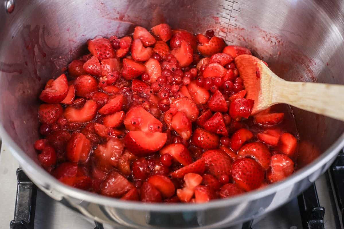 Fruits softening in a maslin pan ready to be turned into jam.