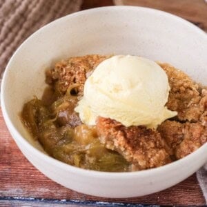Gluten-Free Rhubarb Crumble served into a bowl with ice cream melting on top.