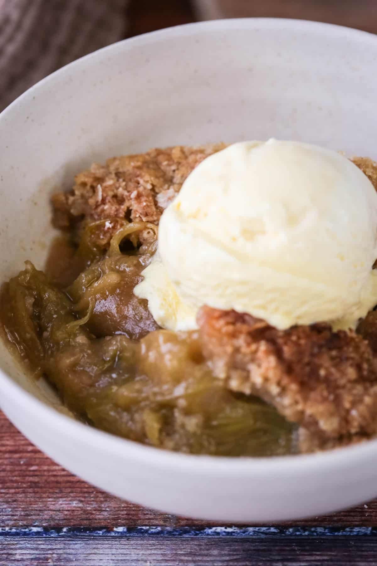 Gluten-Free Rhubarb Crumble served into a bowl with ice cream melting on top.