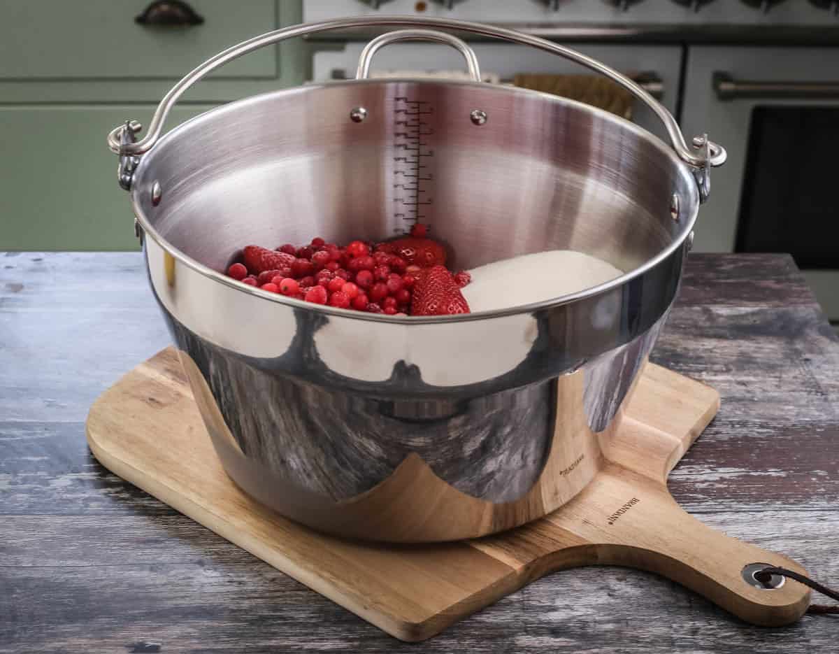 Maslin pan full of strawberries, redcurrants and sugar.