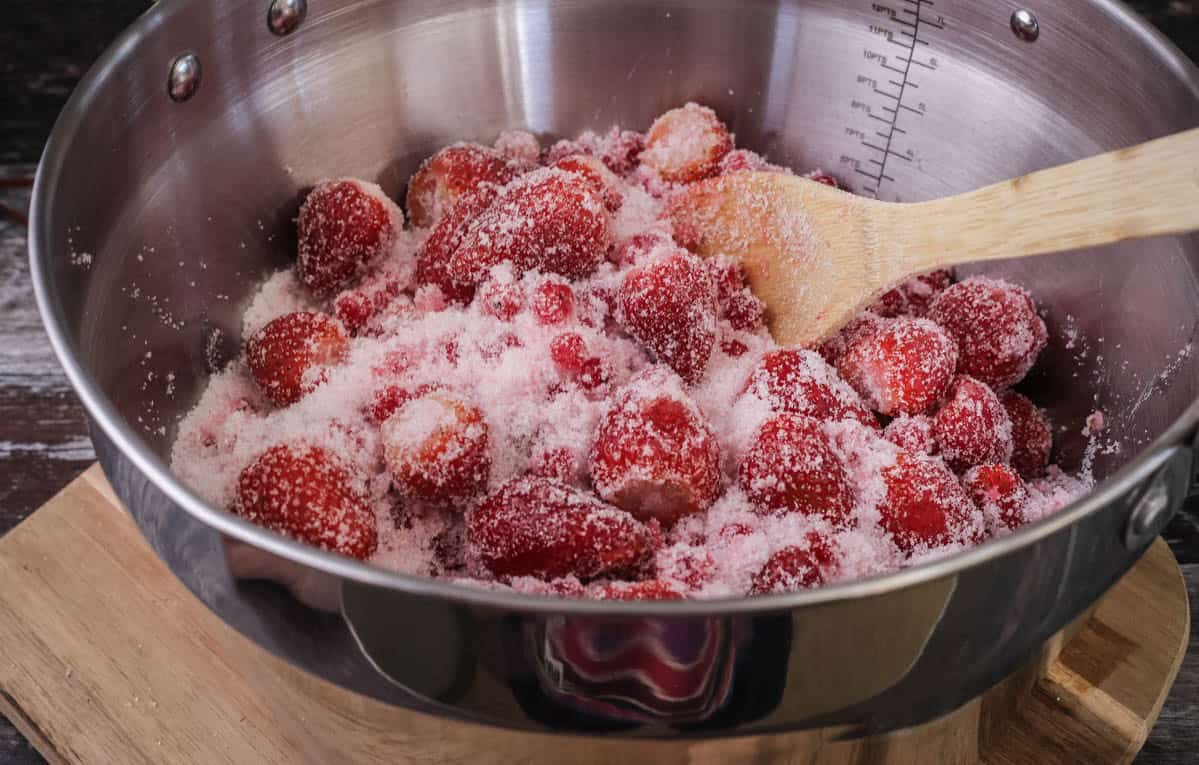 Maslin pan full of strawberries, redcurrants and sugar.