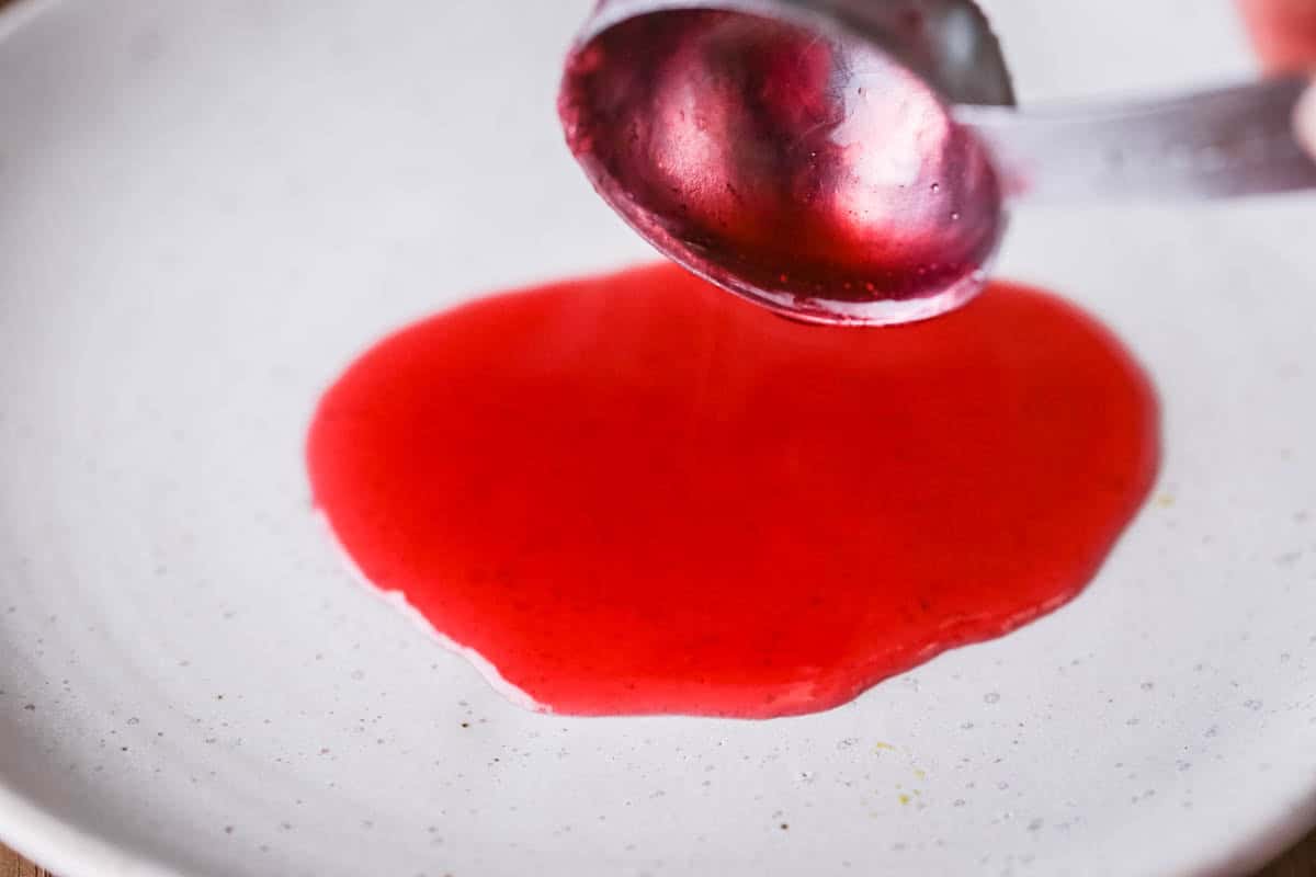 Spoonful of jam poured out onto a saucer.