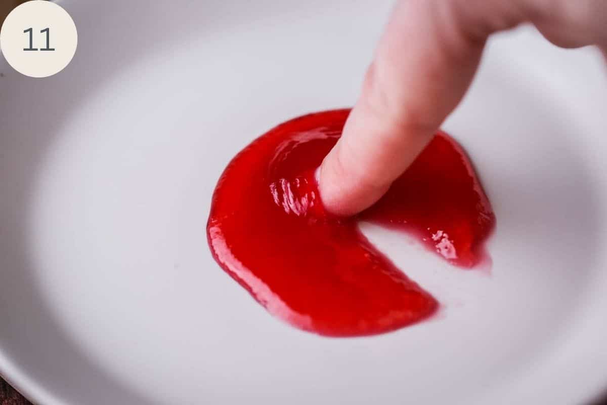 Finger pushing through jam which wrinkles up and leaves a clear path behind to show correct setting point of the jam.