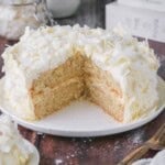 Soft, moist and fluffy slice of gluten-free Coconut Cake on a plate showing the tender crumb.