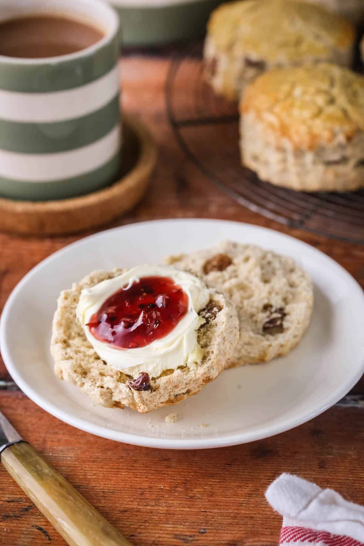 Gluten-free fruit scone halved and layered with clotted cream and fresh homemade jam.