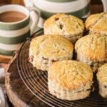 Gluten-free fruit scones on a wire rack next to a cup of tea.