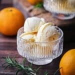 Orange ice cream in a glass bowl.