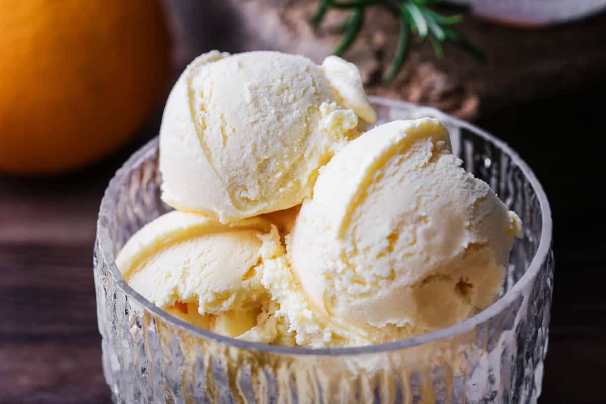 Orange ice cream in a glass bowl.