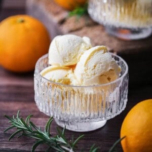 Orange ice cream in a glass bowl.