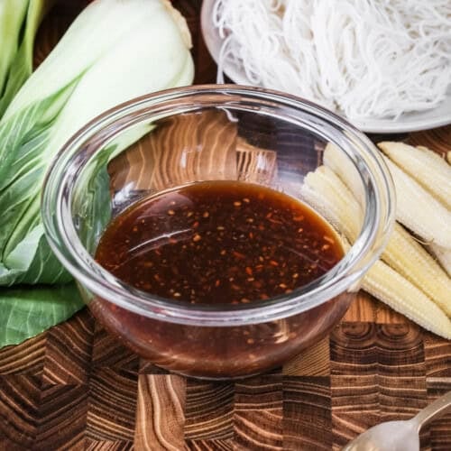 Gluten-Free Stir Fry Sauce in small mixing bowl surrounded by stir fry ingredients.