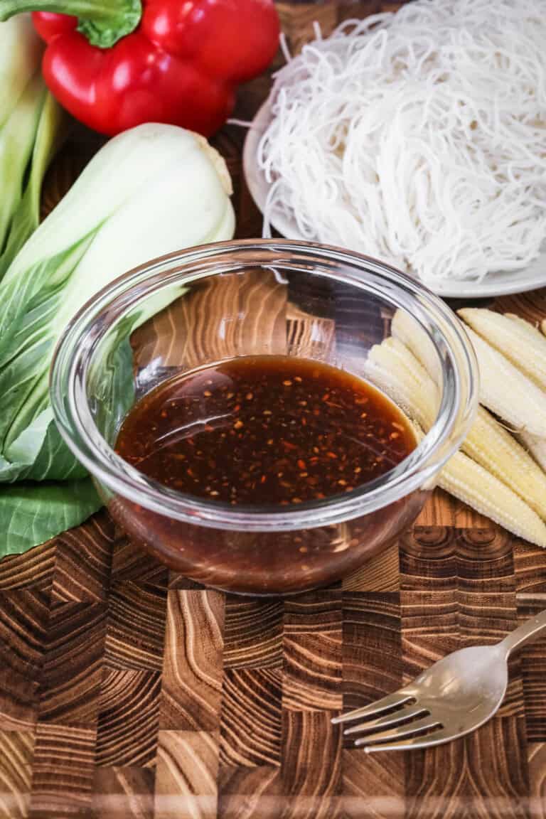 Gluten-Free Stir Fry Sauce in small mixing bowl surrounded by stir fry ingredients.