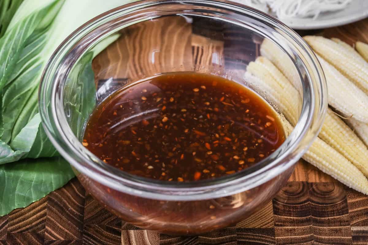 Gluten-Free Stir Fry Sauce in small mixing bowl surrounded by stir fry ingredients.
