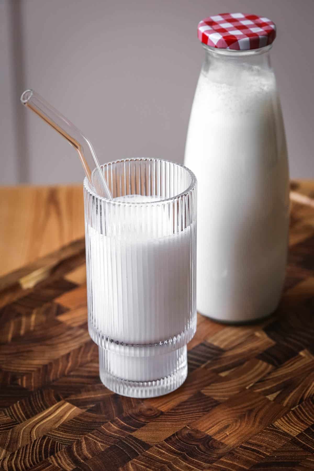 Cashew Nut Milk in a glass in front of full milk bottle.