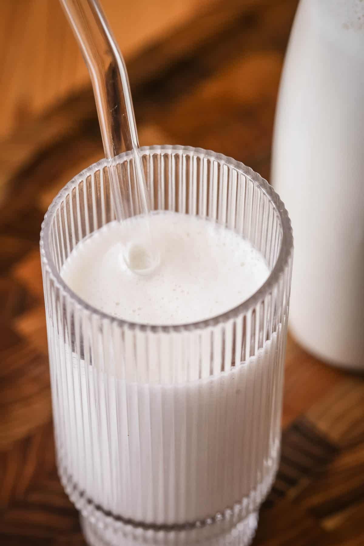 Cashew Nut Milk in a glass with a straw.