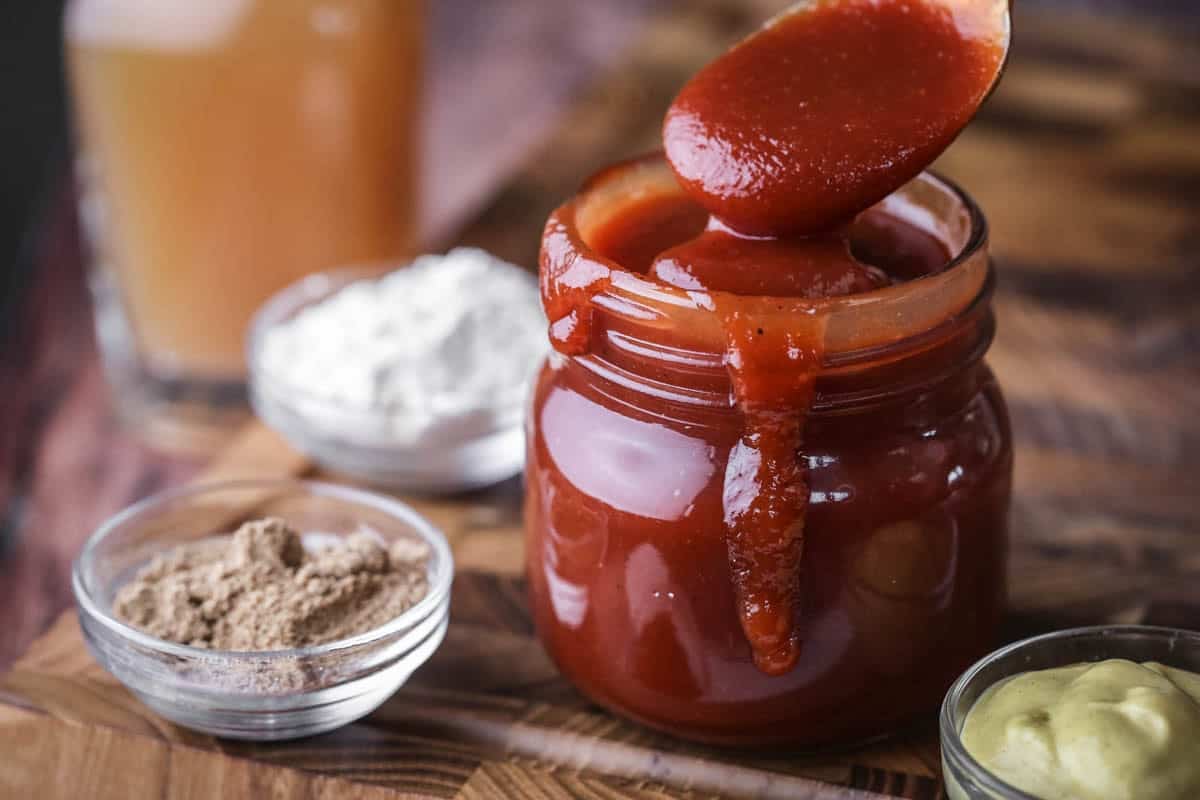 Spoon dipping out of BBQ sauce showing how it's thick and luscious.