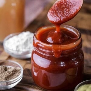 Spoon dipping out of BBQ sauce showing how it's thick and luscious.
