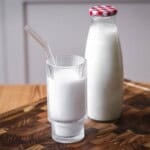 Cashew Nut Milk in a glass in front of full milk bottle.