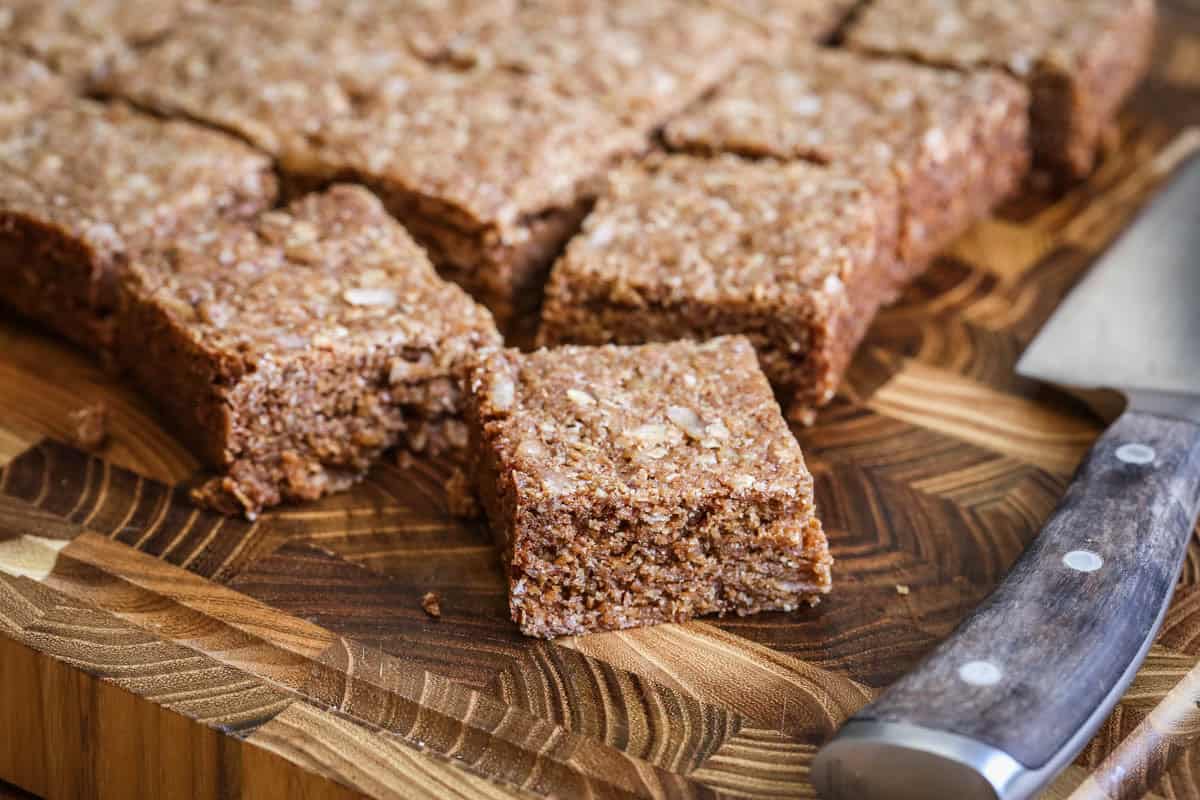 Perfectly cut and square gluten-free flapjacks on wooden board.