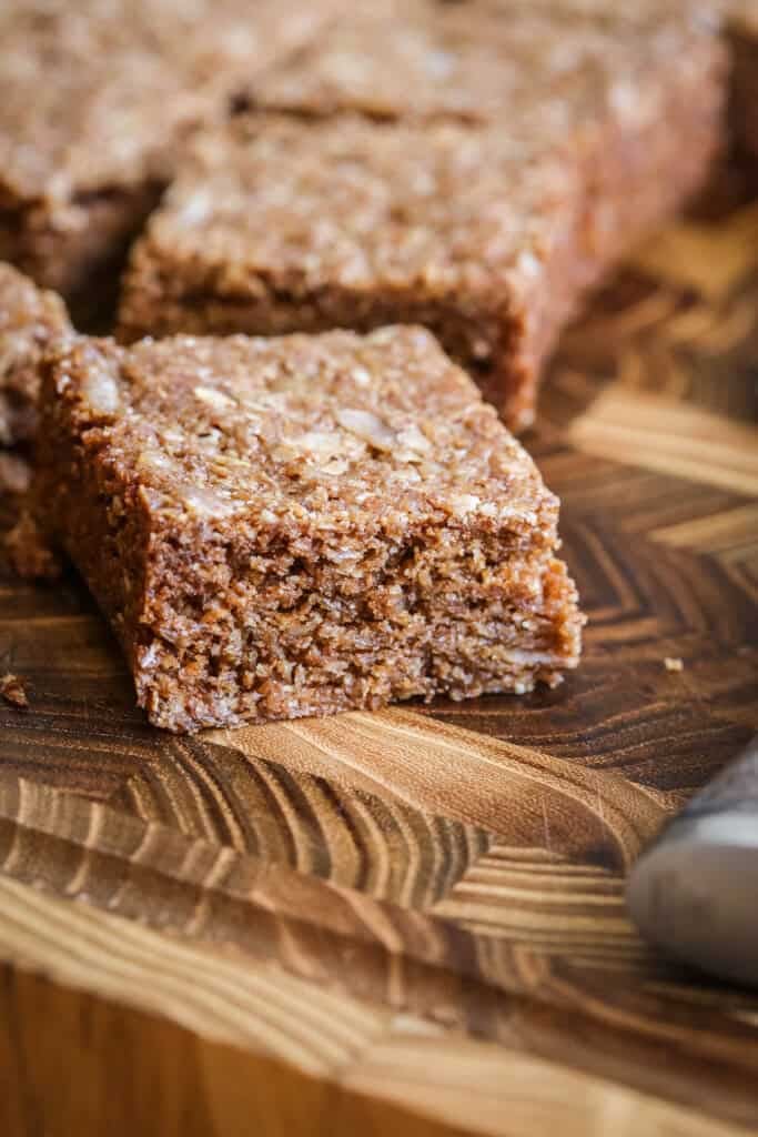 Square of Gluten Free Flapjack on a wooden board.