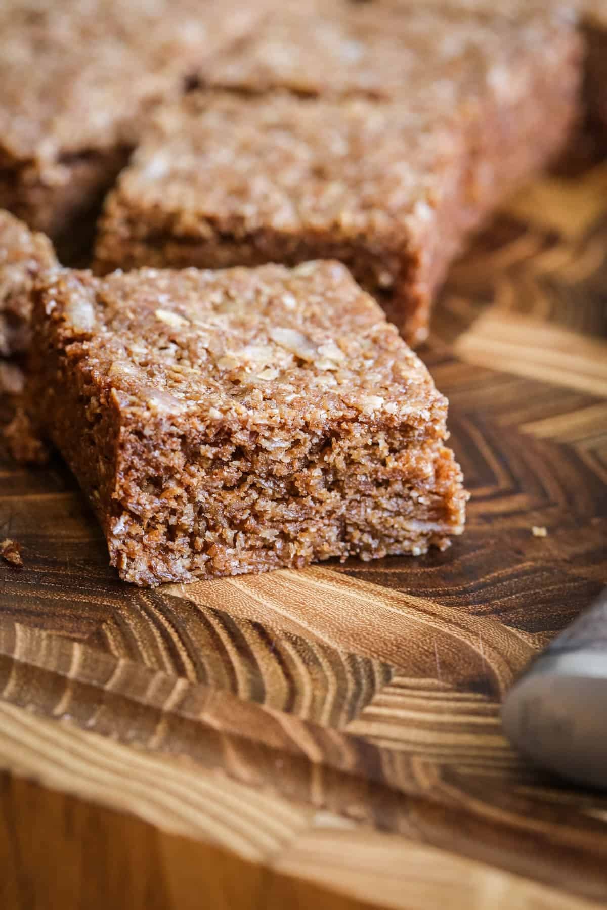 Square of Gluten Free Flapjack on a wooden board.