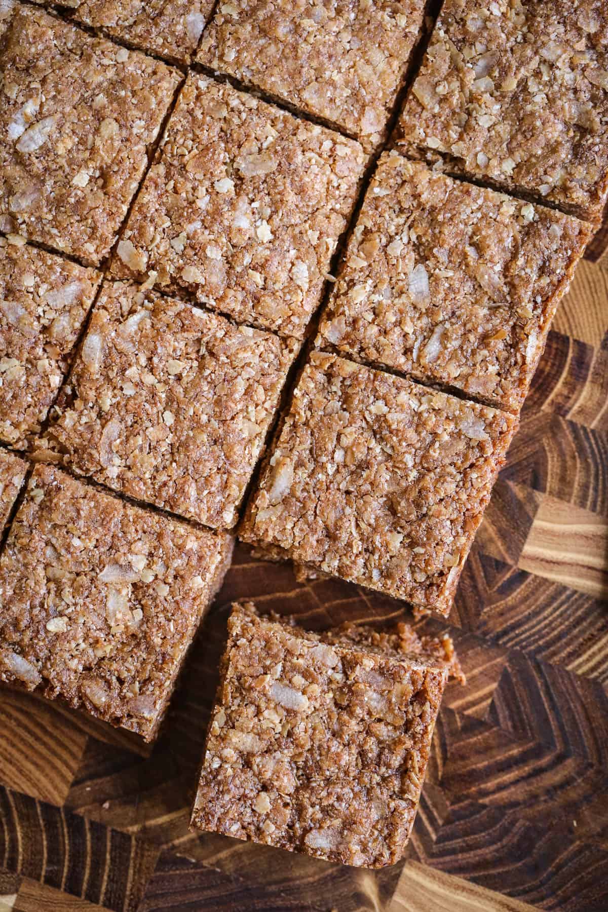 Flapjacks cut into perfect squares on wooden board.