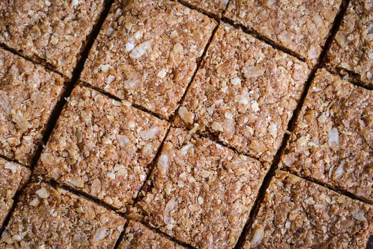 Flapjacks cut into perfect squares on wooden board.