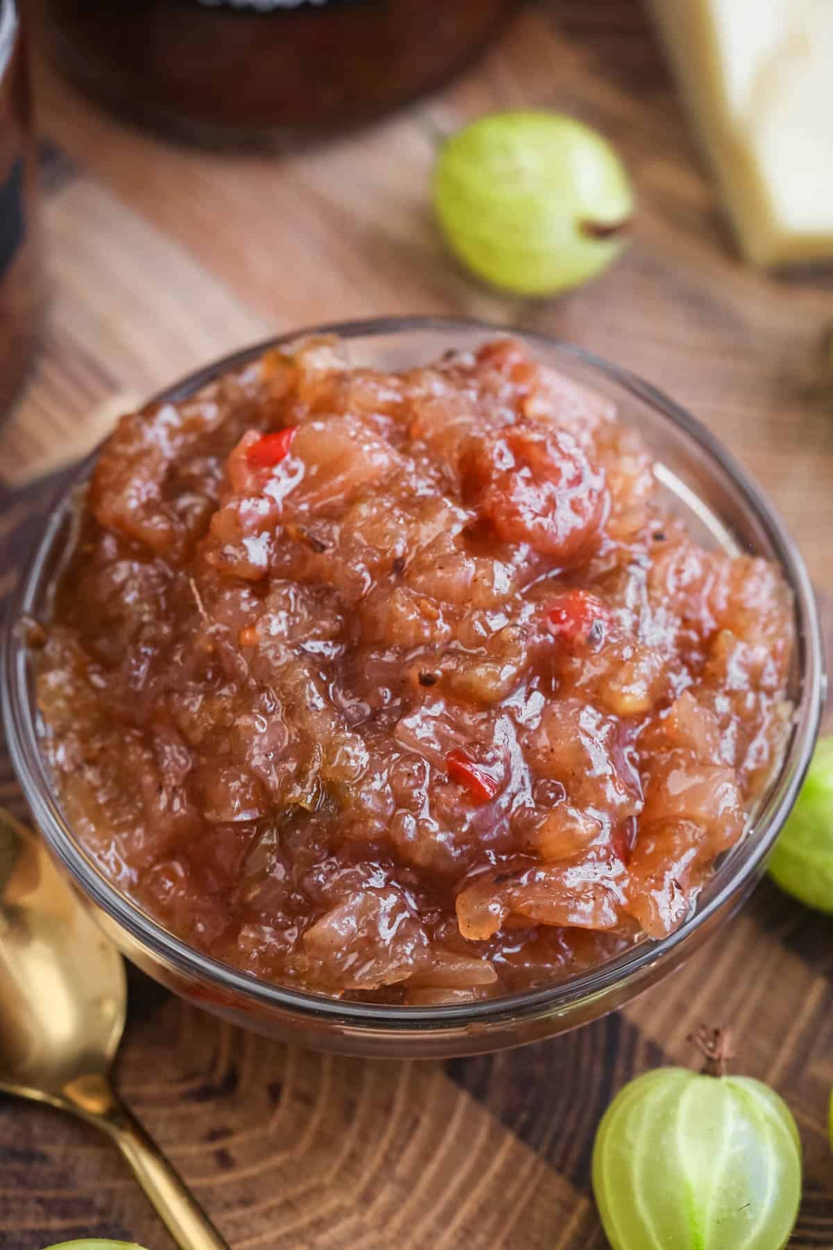Gooseberry Chutney in a small dish, thick with plump gooseberries and apples, flecks of chilli and chunky onion.