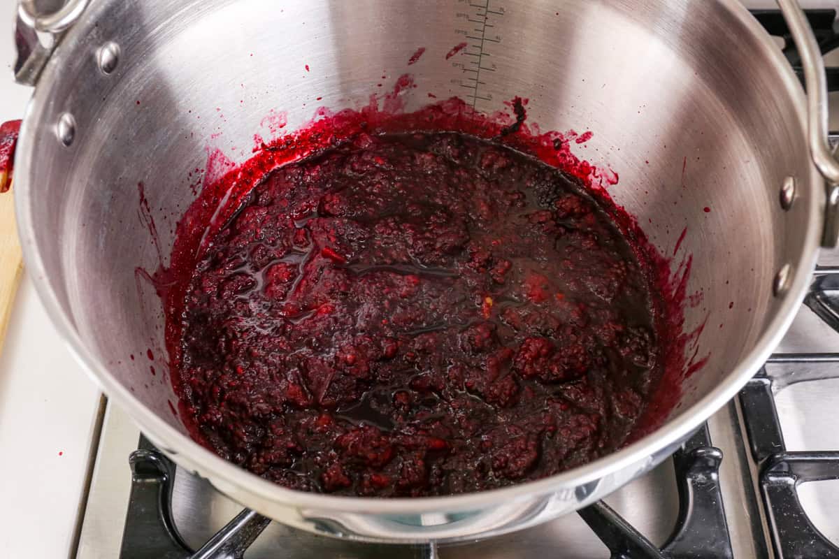 Cooked and softened apple and blackberry in preserving pan.