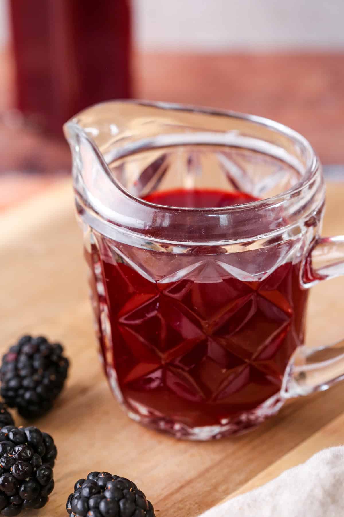 Beautifully claret coloured blackberry vinegar in a small jug.
