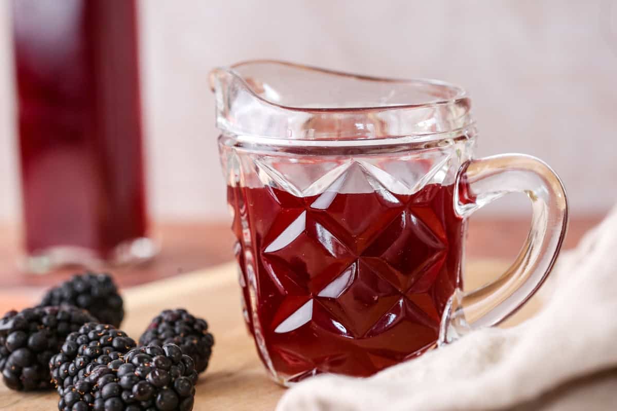 Beautifully claret coloured blackberry vinegar in a small jug.