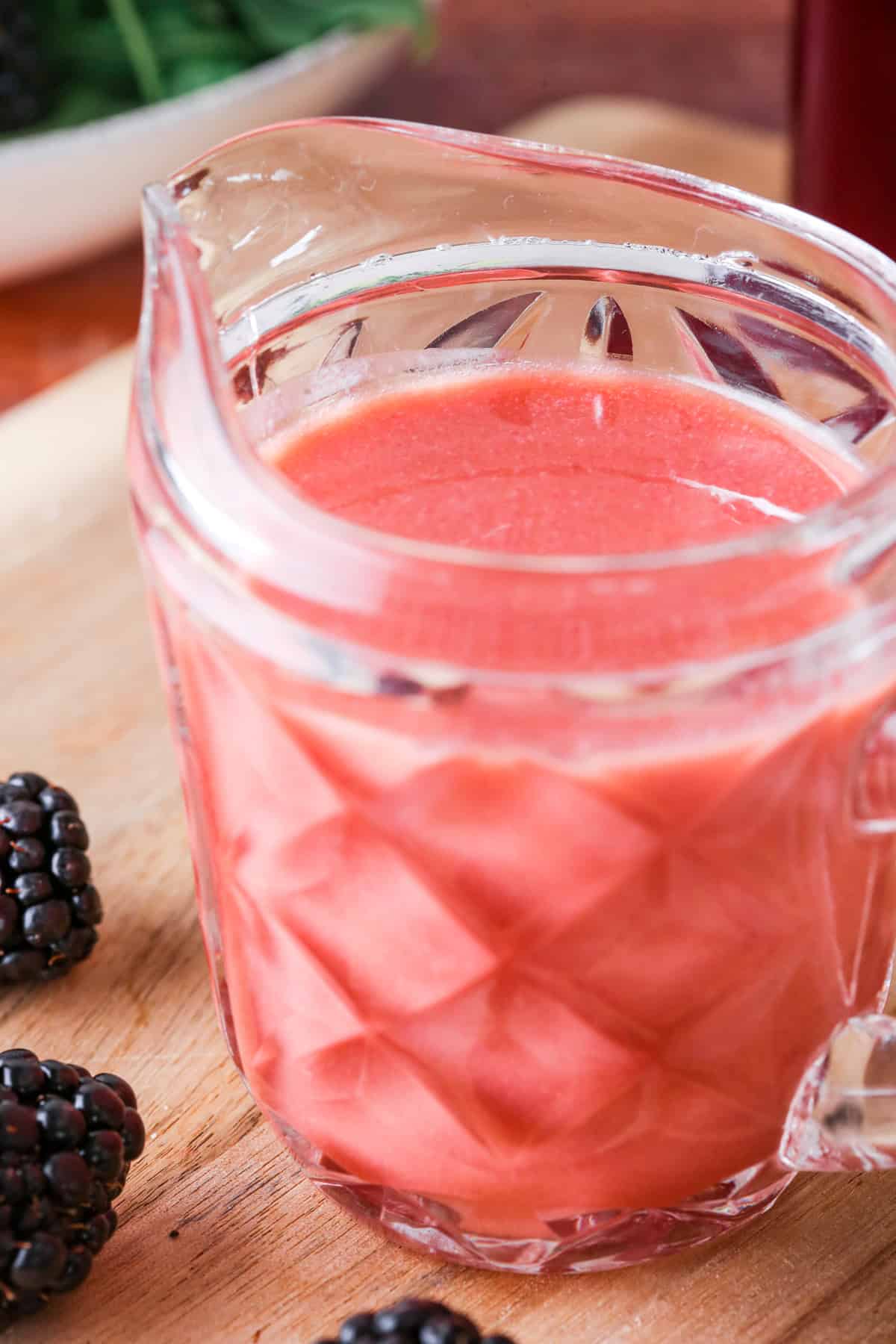 Beautifully pink salad dressing made from blackberry vinegar in a jug.