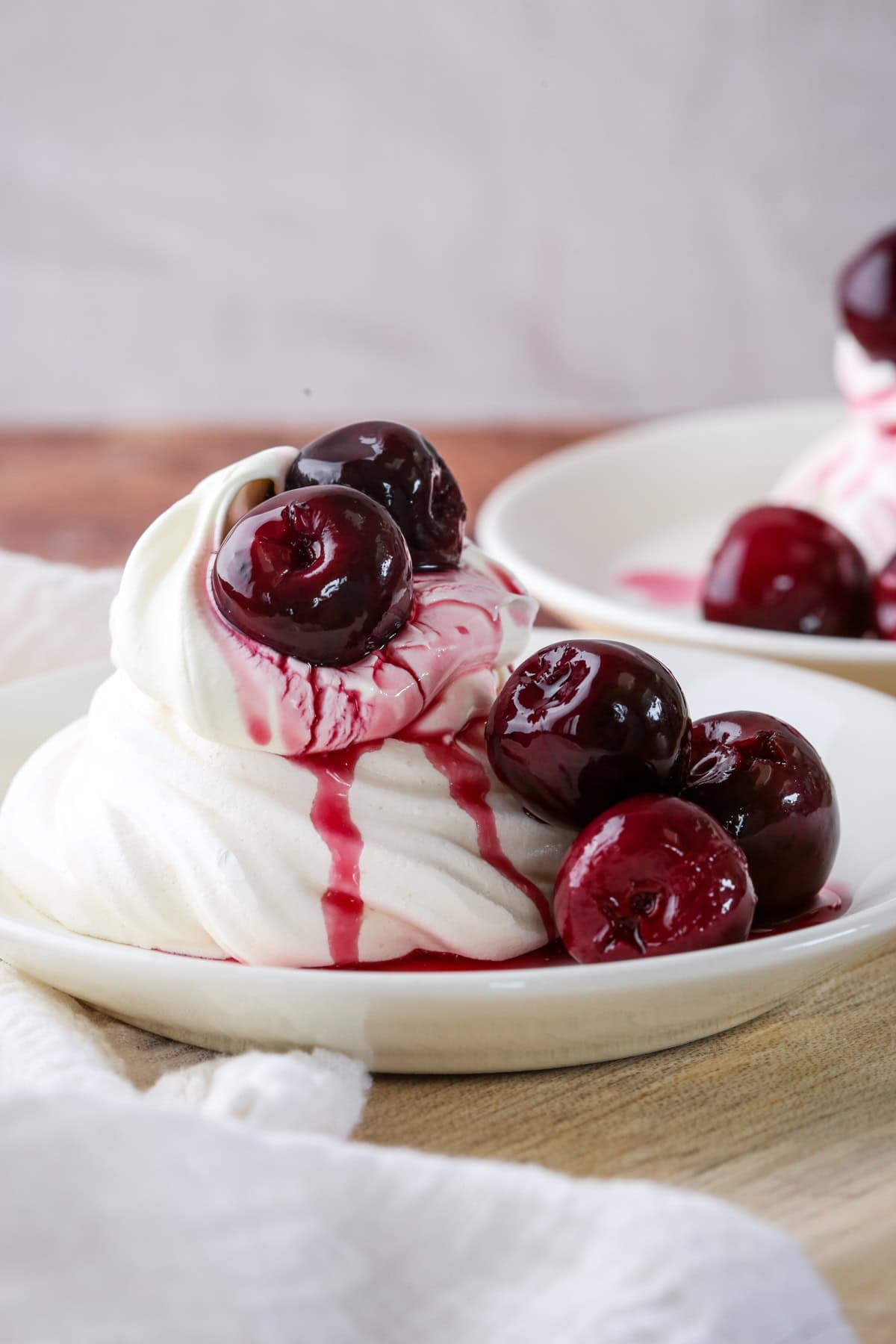 Meringue nest filled with whipped cream and topped with kirsch soaked cherries. A little syrup poured over the top.