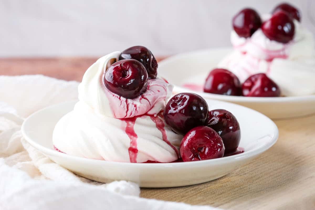 Meringue nest filled with whipped cream and topped with kirsch soaked cherries. A little syrup poured over the top.
