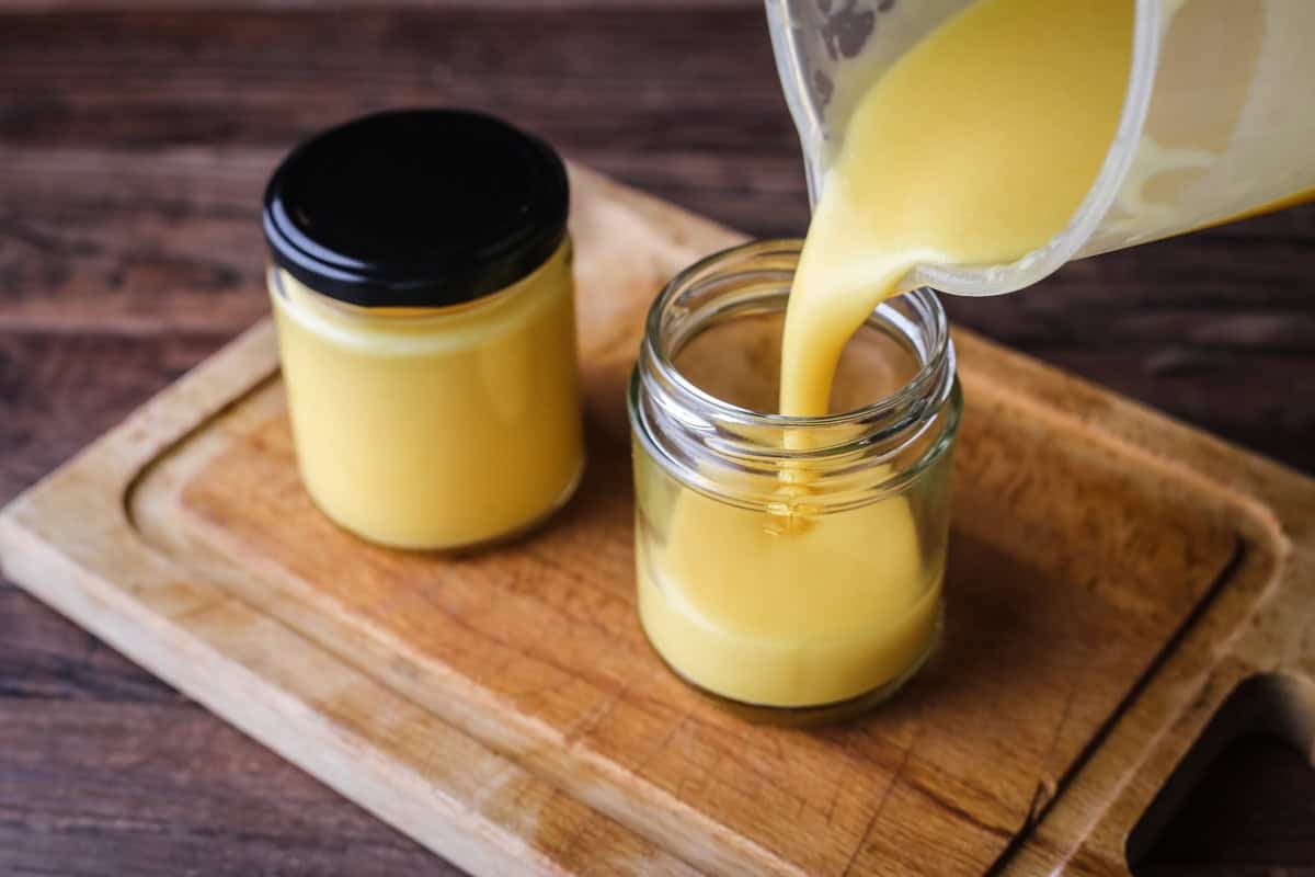 Filling jar of orange curd.