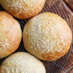 Burger Buns on wire rack cooling, golden brown and scattered with sesame seeds.