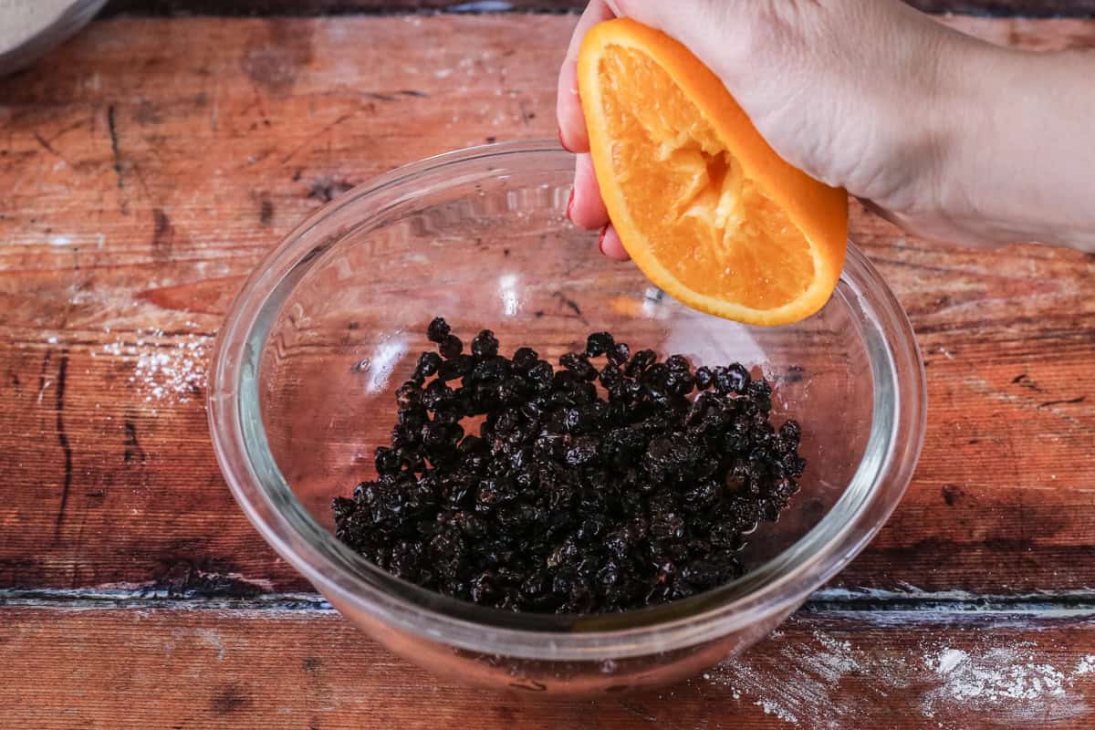 Orange juice squeezed into currants to soak.