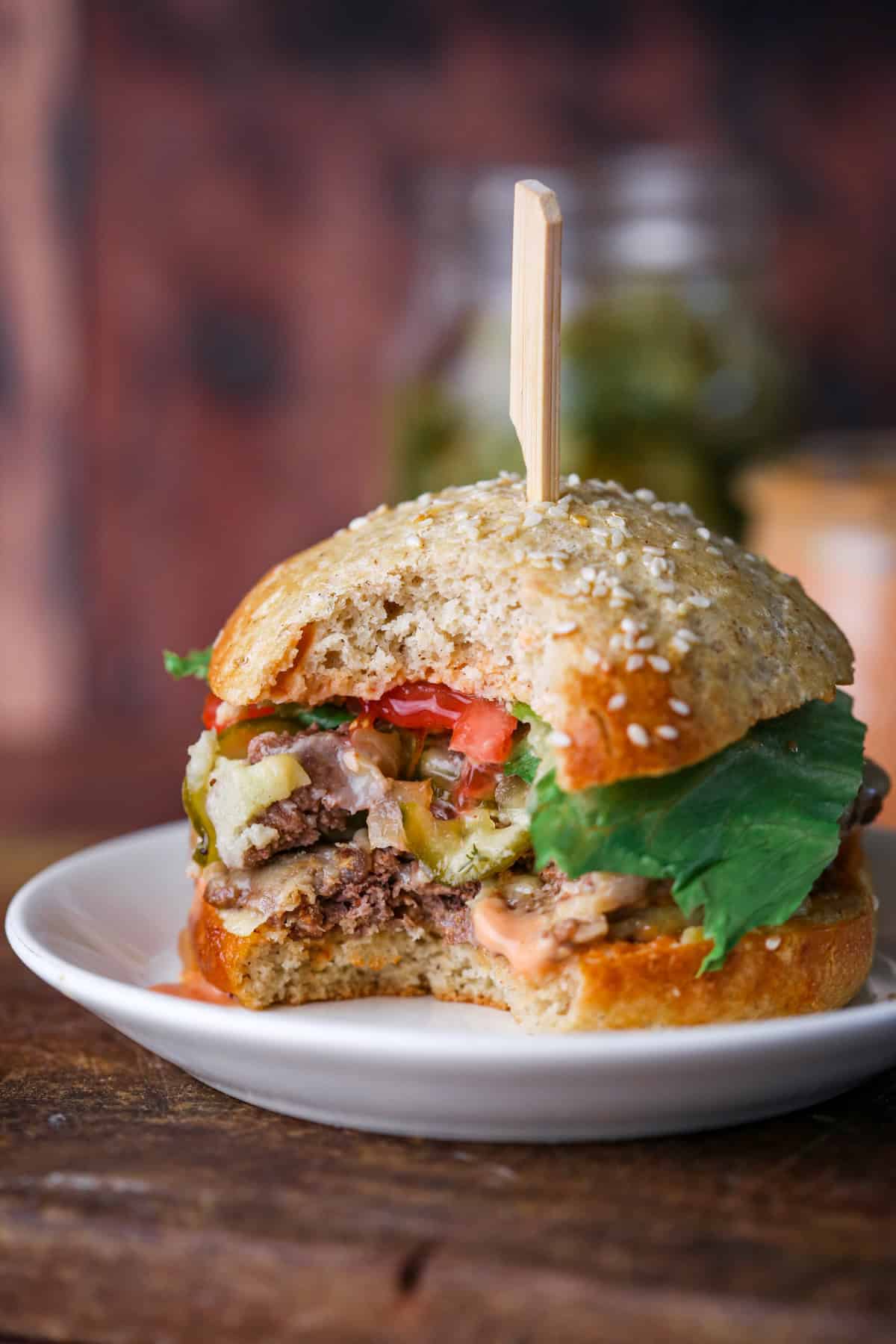 Smash burger showing all the layers and toppings. Juicy and loaded.
