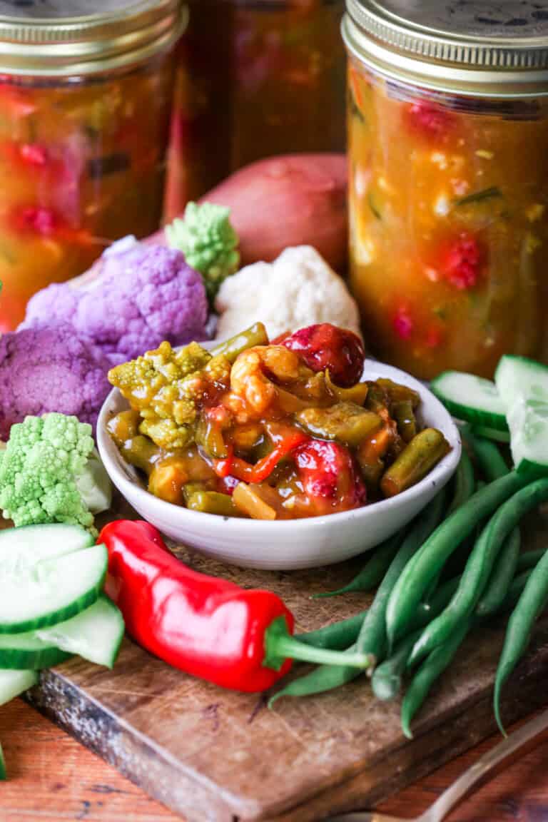 Portion of piccalilli in bowl surrounded by ingredients.