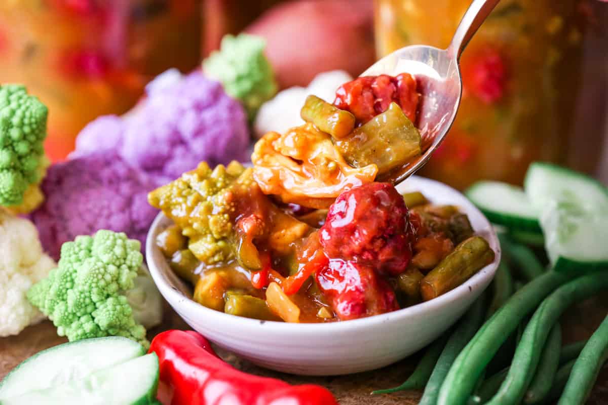 Spooning out piccalilli from bowl.