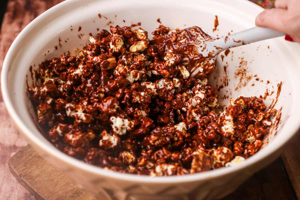 Mixing melted chocolate into ingredients in large bowl.